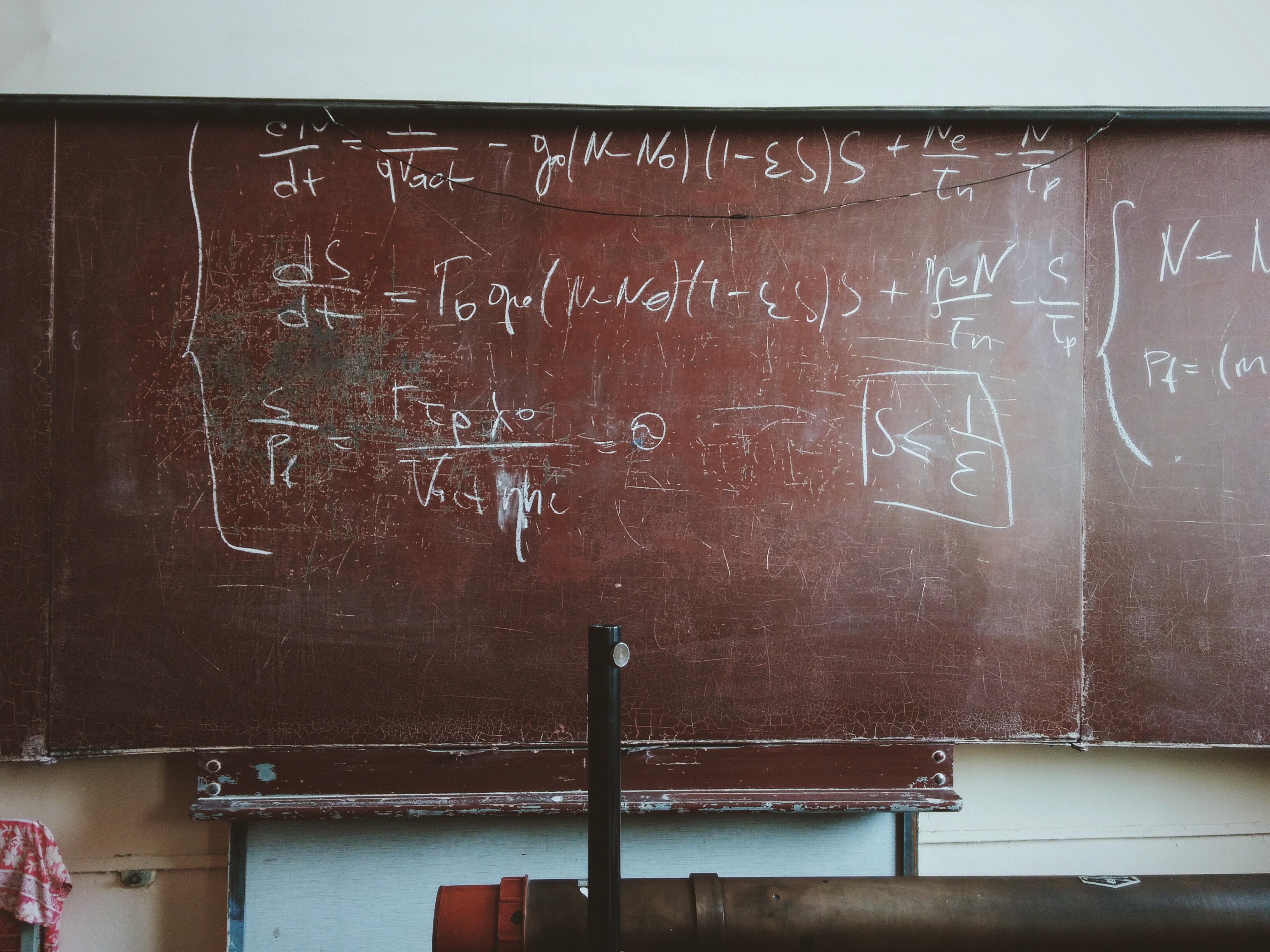 A classroom chalkboard with an elaborate equation drawn on it.