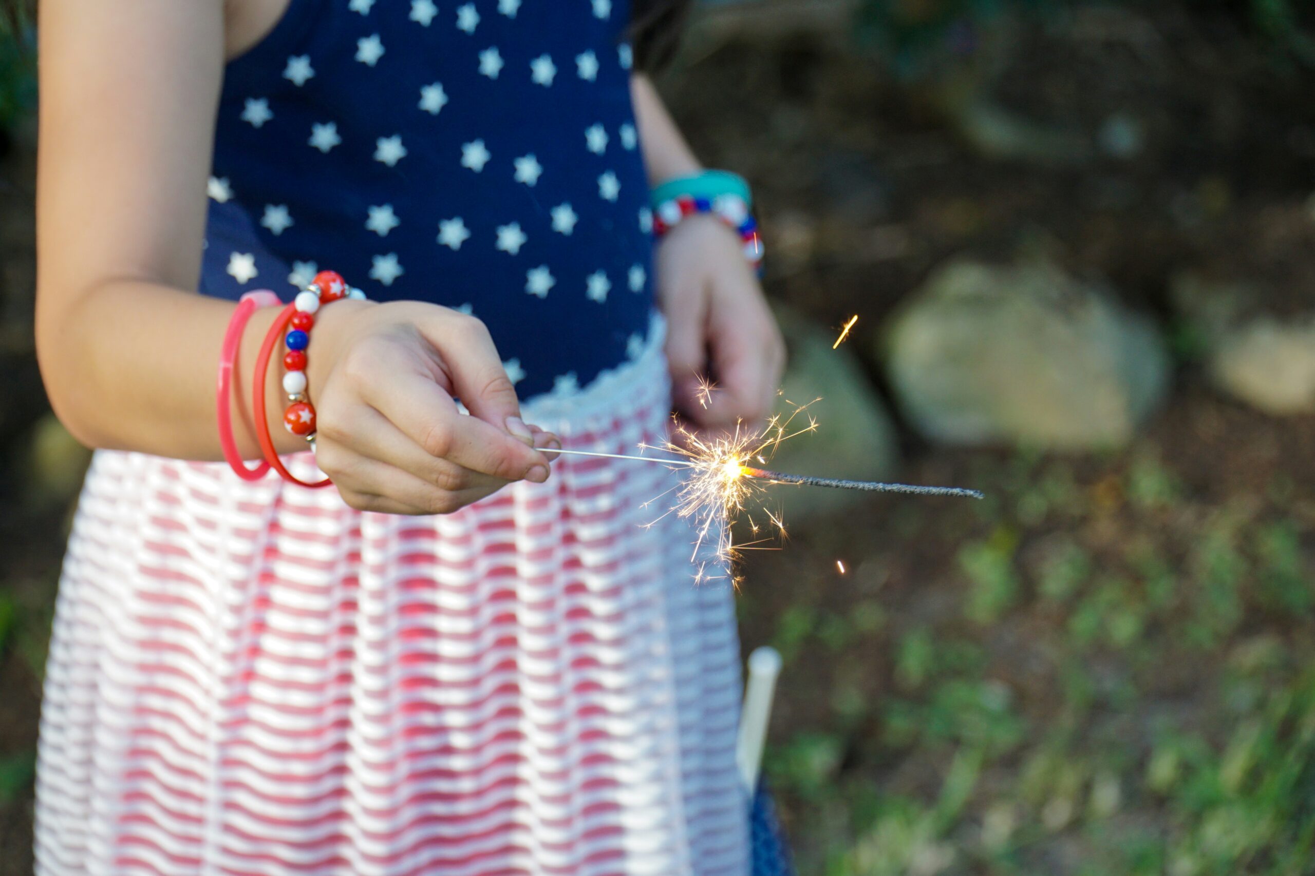 Photo of child in 4th of July outfit with sparkler, Credit to Thomas Park.